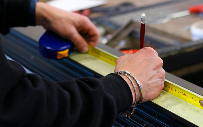Maßgenaue Fertigung von Aluminium-Rollläden durch präzises Vermessen und individuelle Produktion nach Maß.