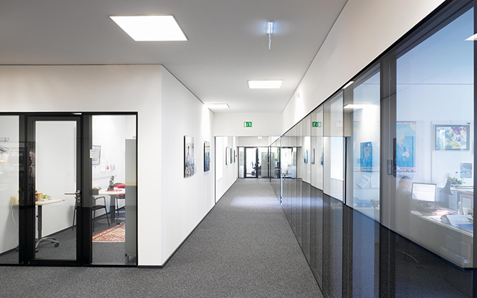 Brandschutzglas als verglaste Trennwand in einem hellen Büroflur