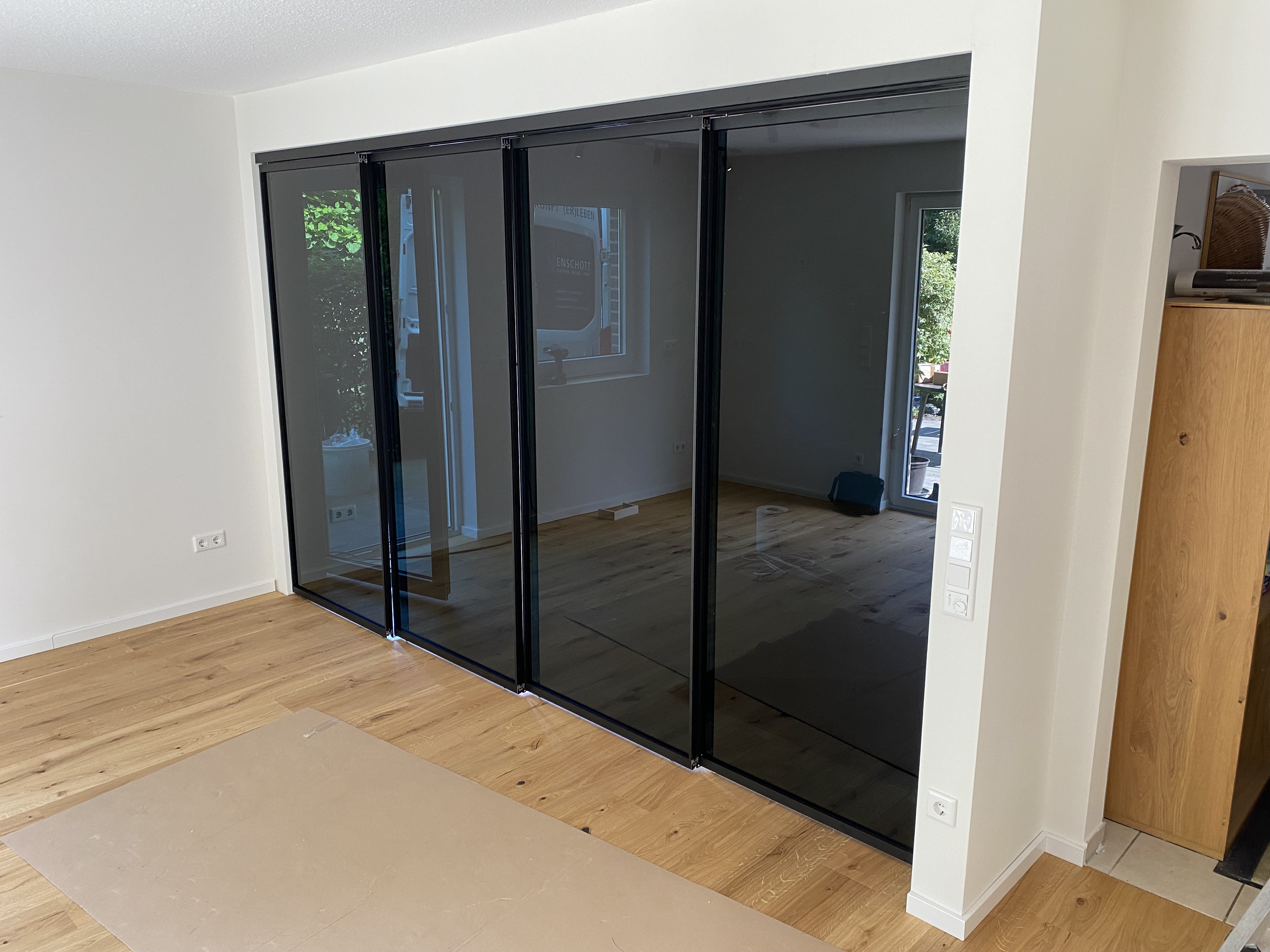 Loft-Schiebetür mit getöntem Glas und schwarzen Aluminiumprofilen zur eleganten Raumtrennung in modernem Wohnambiente.