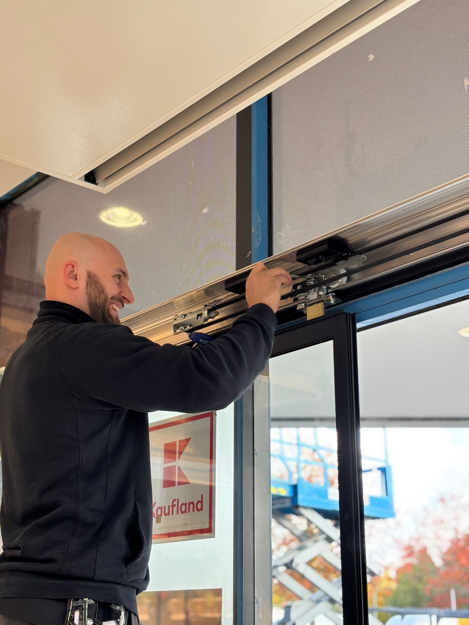 Montage einer automatischen Schiebetür in einem öffentlichen Gebäude mit Installation der Antriebstechnik.