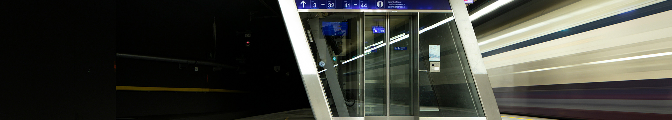 Moderner Bahnhofsaufzug mit Aluminium-Glas-Konstruktion für barrierefreie Verkehrsinfrastruktur und öffentlichen Gebäudebau.