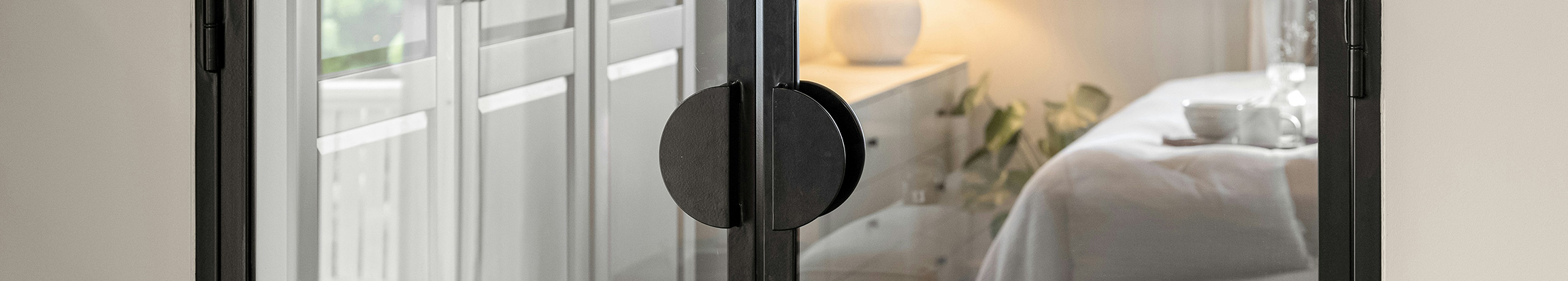 Lofttür aus Aluminium und Glas mit schwarzen Profilen für moderne Raumtrennung und lichtdurchflutete Wohnräume.
