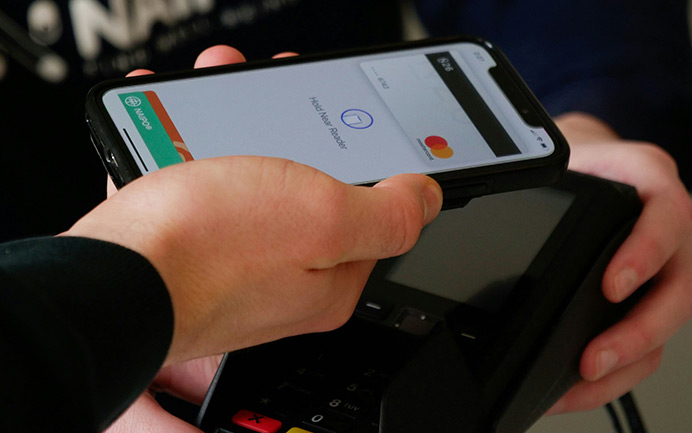 Kontaktlose Zahlung mit Smartphone am Kartenlesegerät für schnelle und sichere Bezahlung von Ersatzteilen und Industriebedarf.