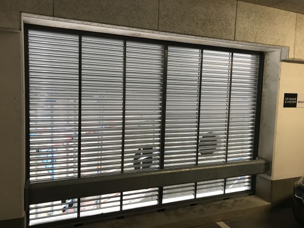 Maßgefertigtes Aluminium-Lüftungsgitter in einer Pfosten-Riegel-Fassade für moderne Gebäudetechnik.