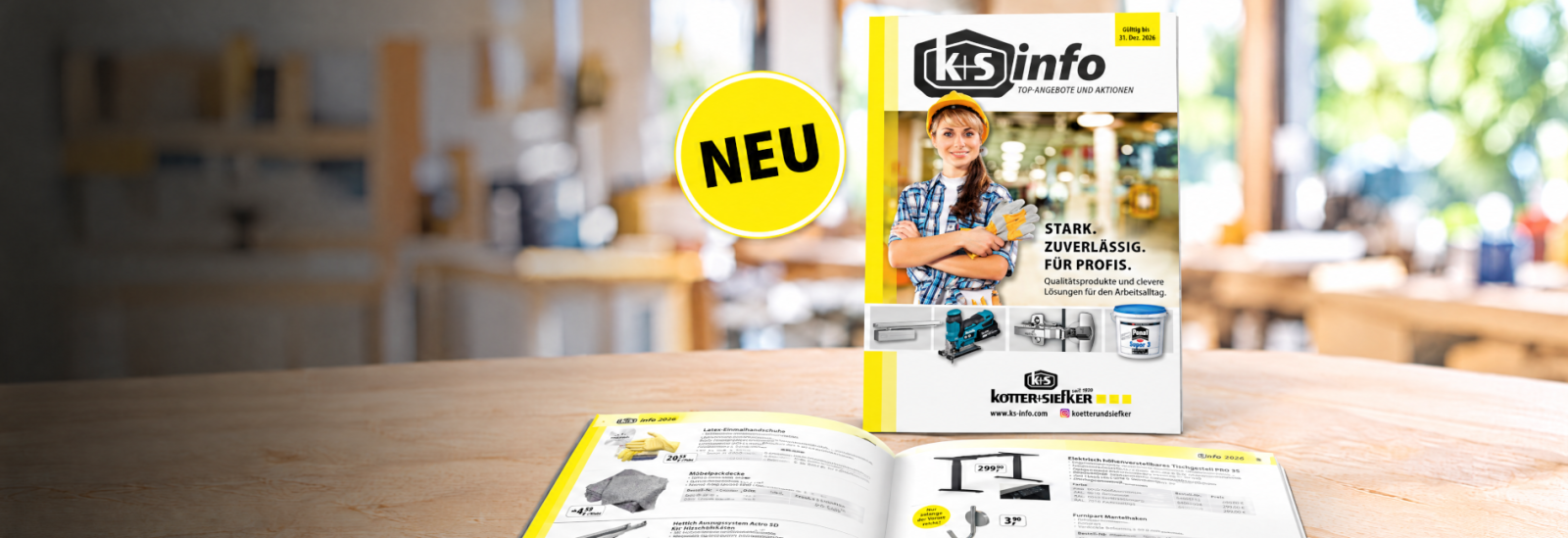 KS-Info-Katalog 2026 mit aktuellen Angeboten, aufrecht und aufgeschlagen auf einer Werkbank, daneben ein gelber „NEU“-Hinweis.