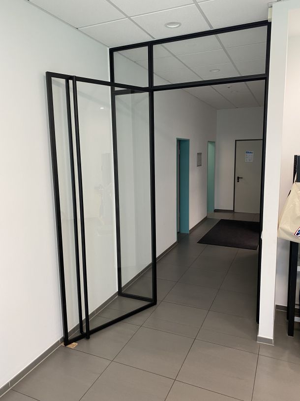 Stahl-Glas-Eingangselement mit Seitenteil für moderne Büro- und Gewerberäume.