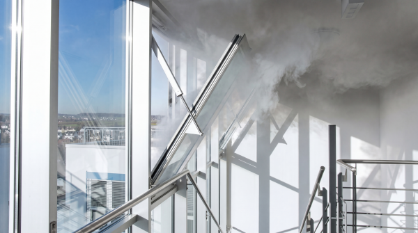 Geöffnete Rauch- und Wärmeabzugsanlage (RWA) mit natürlicher Entrauchung über Fassadenfenster, effektive Brandschutztechnik für sichere Flucht- und Rettungswege.